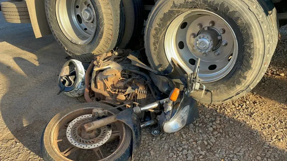 MOTOCICLETA FICA PRESA EM RODADO DE CAMINHÃO APÓS COLISÃO